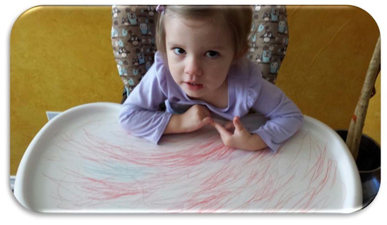 Child coloring on high chair.