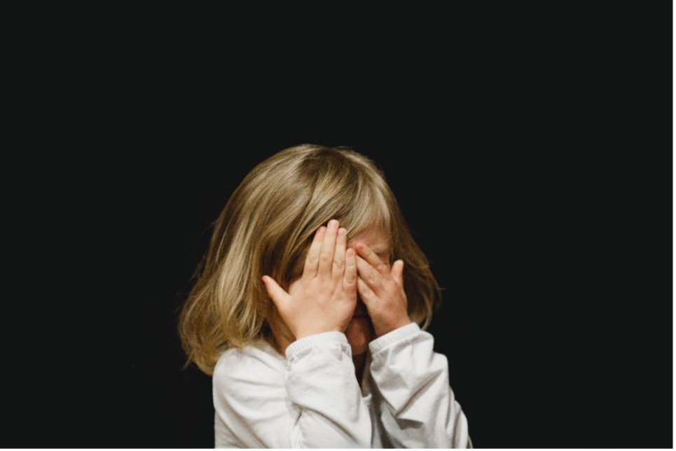 Child covering eyes playing hide and seek. 