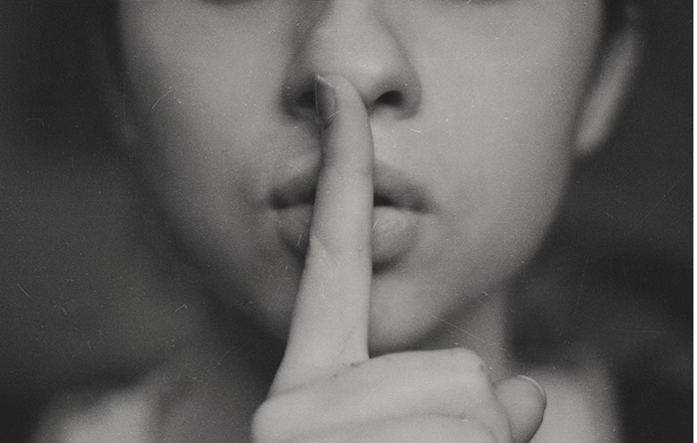 Woman signaling to be quiet with her finger.