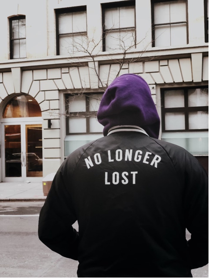 Person with coat that says no longer lost on the back. 