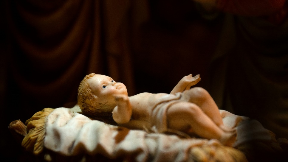 a statue of a baby laying on top of a bed